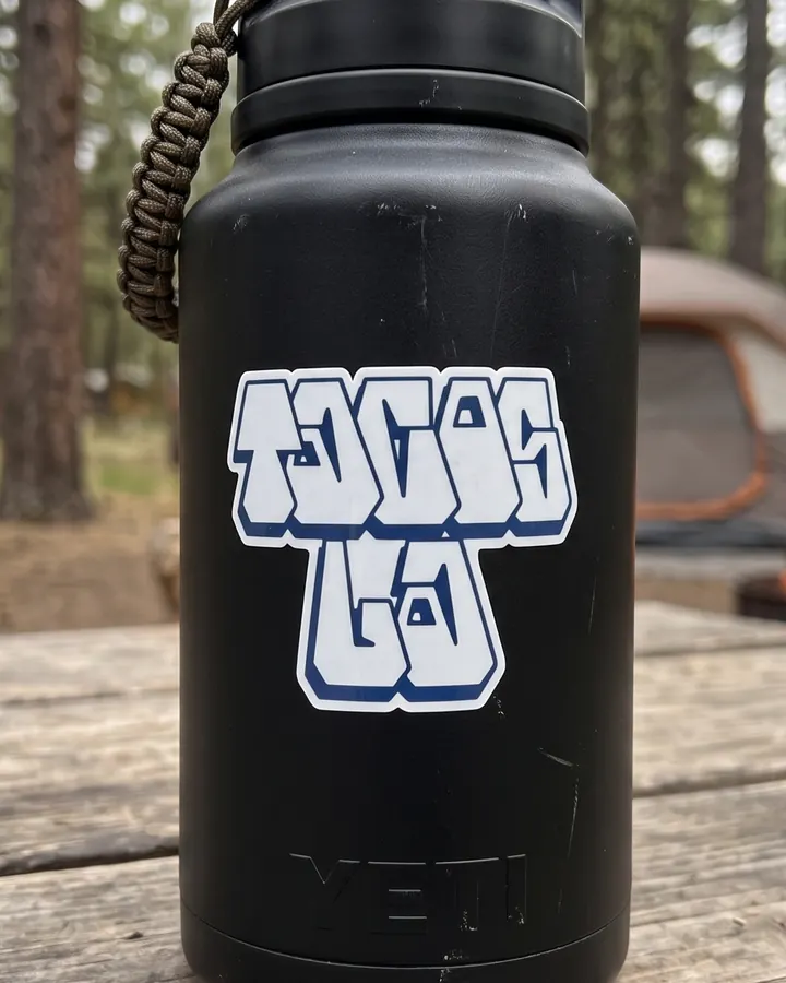 A Tacos LA logo sticker on a black drink bottle